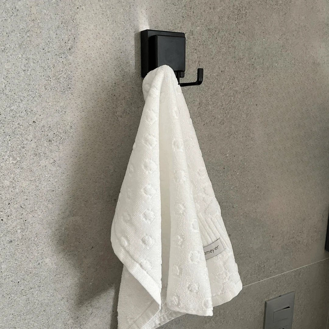 Gancho Duplo de Parede Ventosa Preto Fosco segurando uma toalha na parede do banheiro
